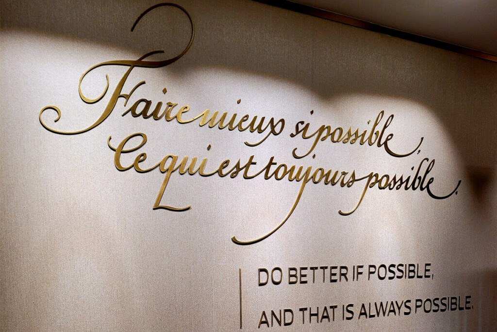 Parede do VIP Lounge da Vacheron Constantin em Lisboa onde está escrito: "Faure mieux si possible ce qui est toujours possible"