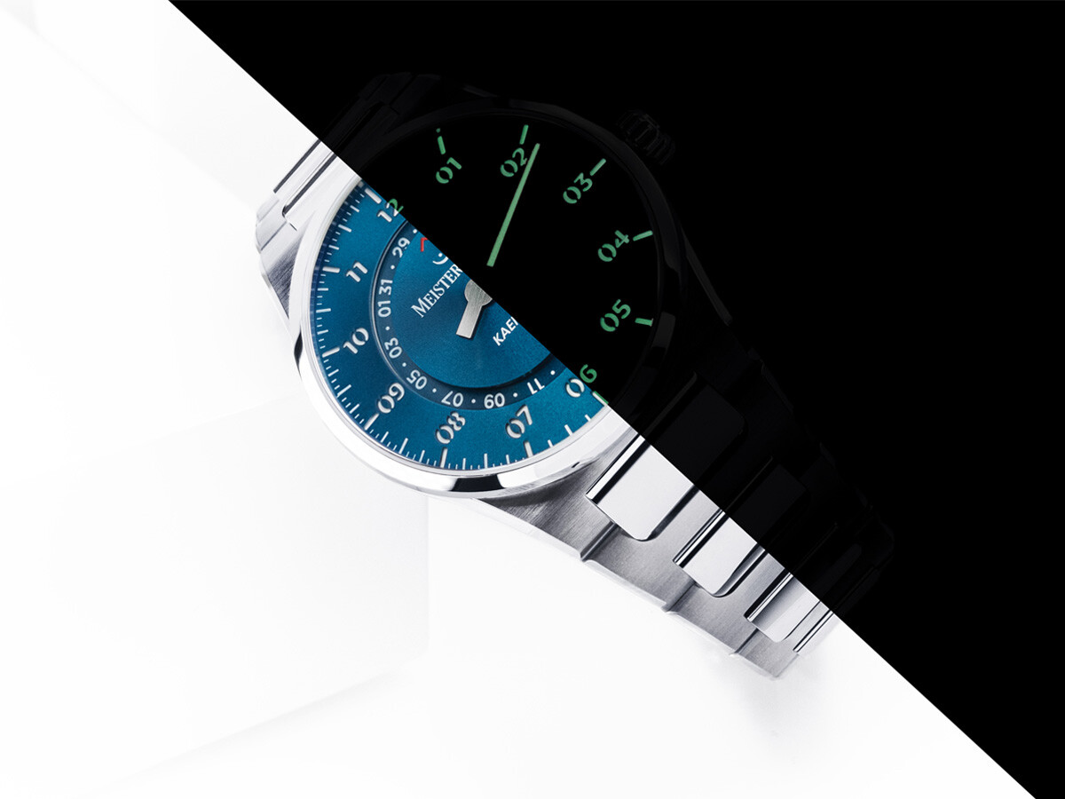 Relógio MeisterSinger Kaenos com mostrador de duas camadas e bracelete metálica integrada, de onde se destaca a luminescência