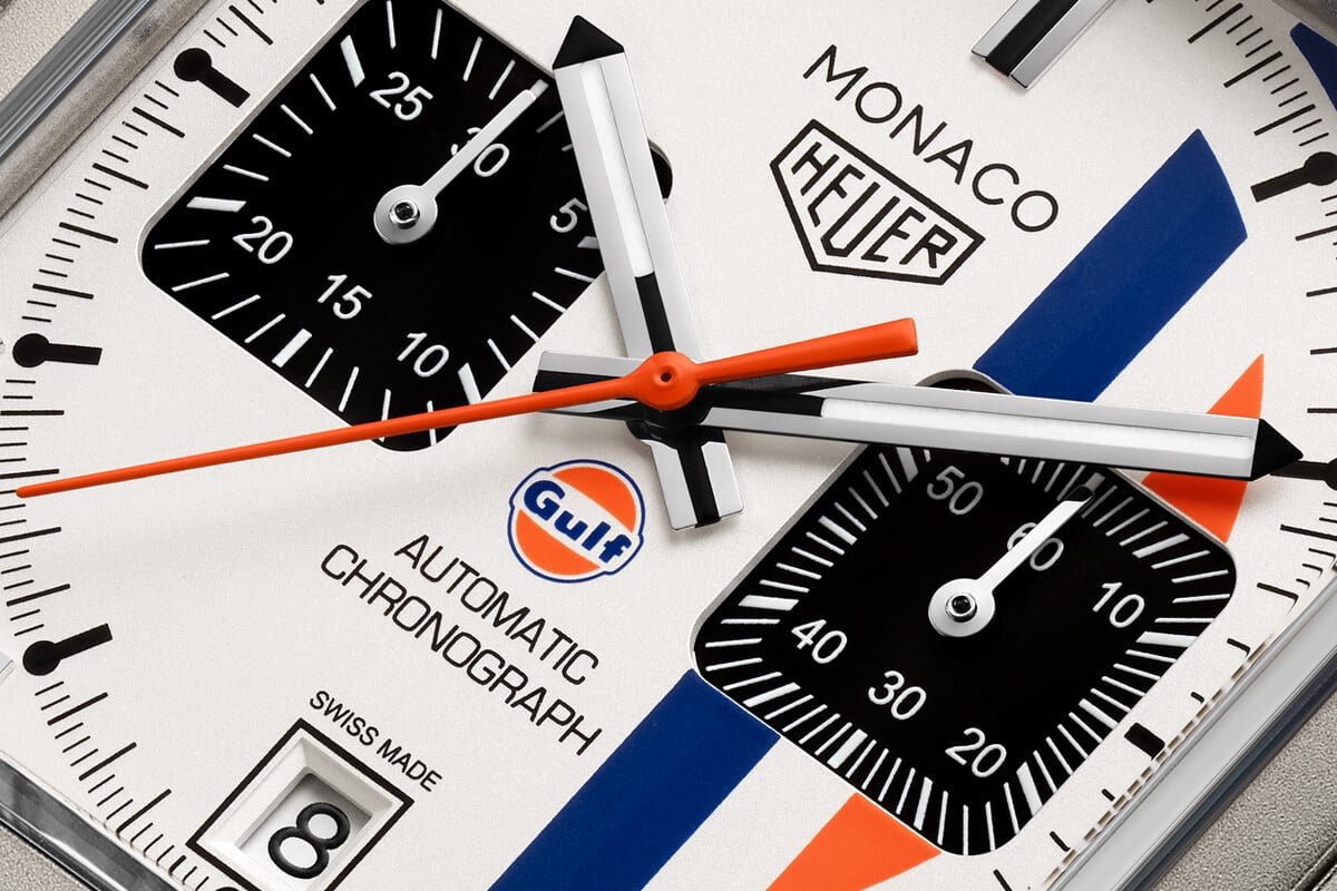 Detalhe do mostrador do relógio de pulso Monaco Chronograph x Gulf com fundo branco e riscas azul e laranja, alusivas à Gulf