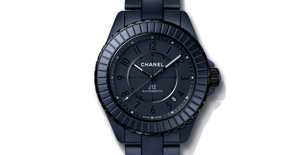 Relógio Chanel J12 automático em cerâmica azul-escura, com bracelete e mostrador no mesmo tom, sobre fundo branco.