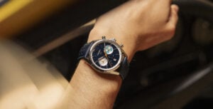 Relógio TAG Heuer Carrera Chronograph Limited Edition 2025 com mostrador azul, submostradores prateado e bicolor, e pulseira azul no pulso de uma pessoa.