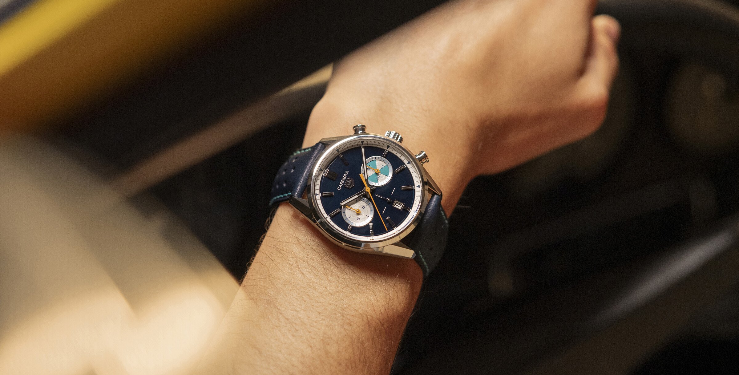Relógio TAG Heuer Carrera Chronograph Limited Edition 2025 com mostrador azul, submostradores prateado e bicolor, e pulseira azul no pulso de uma pessoa.