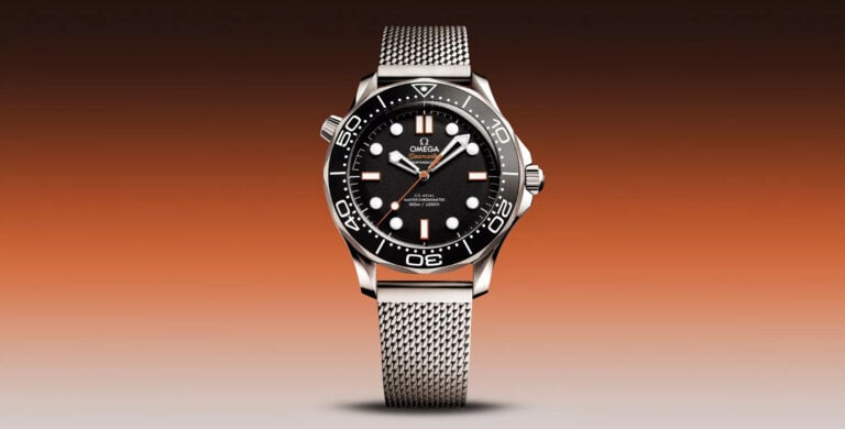 Relógio Omega Seamaster Diver 300M com mostrador preto, luneta preta rotativa e bracelete em malha de aço, sobre fundo em dégradé laranja.