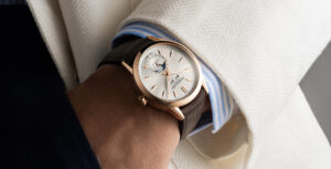 Relógio Raymond Weil Freelancer no pulso de uma pessoa, com caixa em ouro rosa, mostrador prateado e indicação de fases da lua.