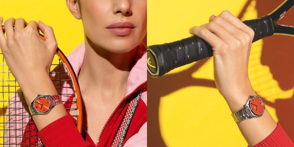 Mulher a segurar uma raquete de ténis com um relógio Ebel Classic Sport de mostrador laranja no pulso, sobre fundo amarelo e mão de uma pessoa a segurar uma raquete de ténis com fundo amarelo e sombra da rede. No pulso, um relógio desportivo Ebel com bracelete metálica e mostrador laranja. Edição especial do Sport Classique de 33mm dedicada ao ténis | Foto: Ebel