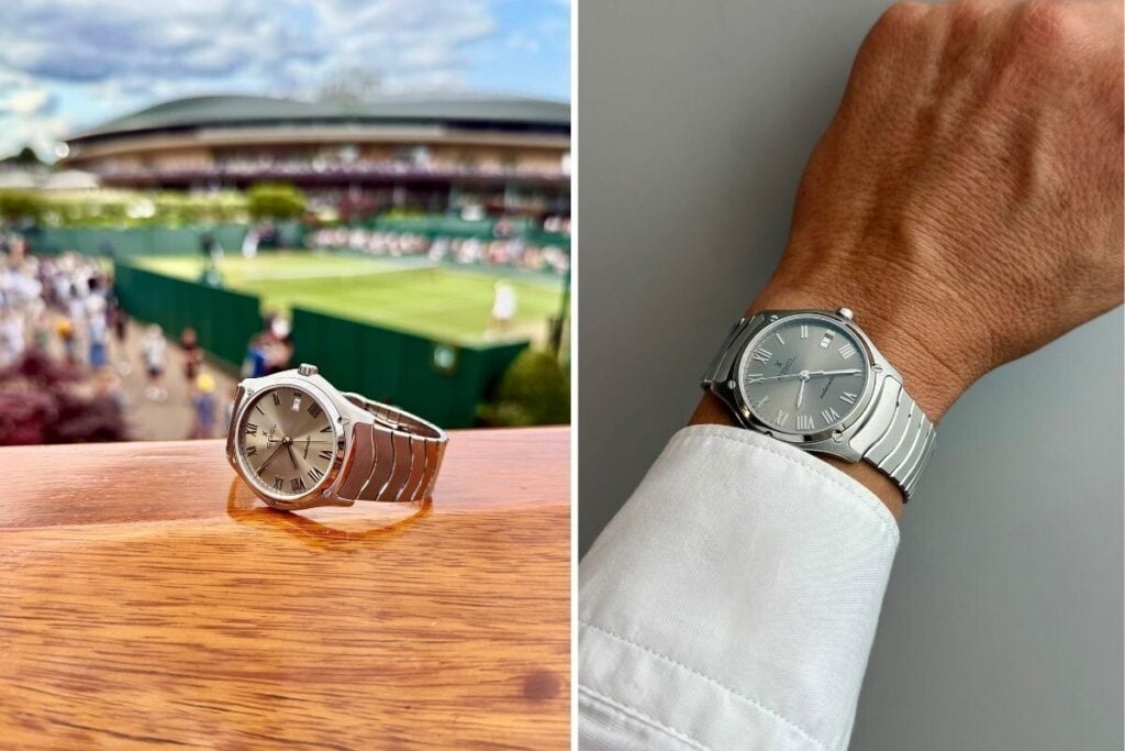 Relógio Ebel Classic Sport em primeiro plano sobre uma superfície de madeira, com um court de ténis de Wimbledon desfocado ao fundo e pulso com relógio Ebel Classic