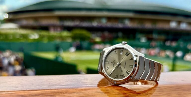 Relógio Ebel Classic Sport em primeiro plano sobre uma superfície de madeira, com fundo desfocado.