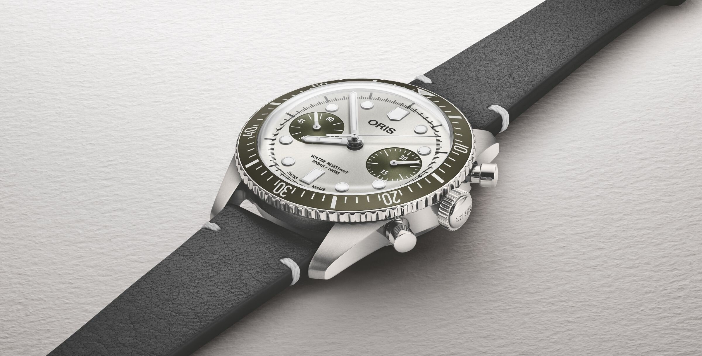 O relógio Oris Divers Sixty-Five Chronograph destacando a coroa, botões e luneta rotativa verde.