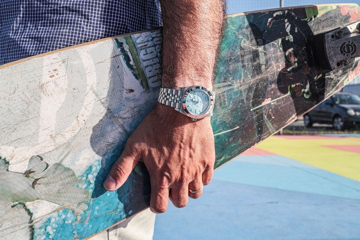O relógio Tudor Black Bay 54 Blue Lagoon num pulso que segura um skate