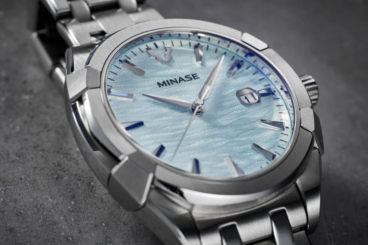 Close-up do mostrador do relógio Minase Uruga Ice Blue com textura ondulada azul claro e marcadores prateados.