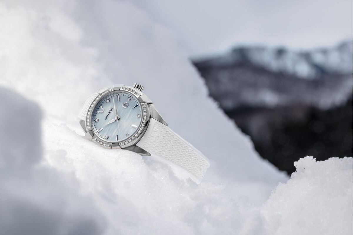 Um relógio Minase Uruga Ice Blue parcialmente cobertos por neve branca, representando a inspiração do inverno japonês.