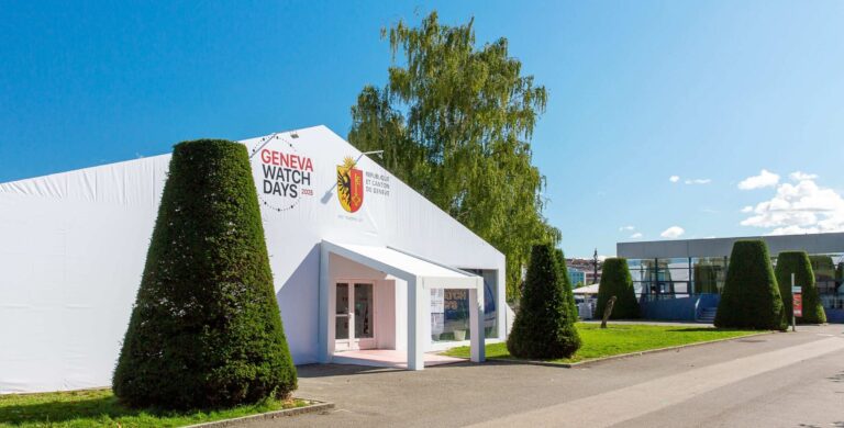 Estrutura branca com logotipo do Geneva Watch Days 2025 e brasão de Genebra, servindo como entrada principal do evento.
