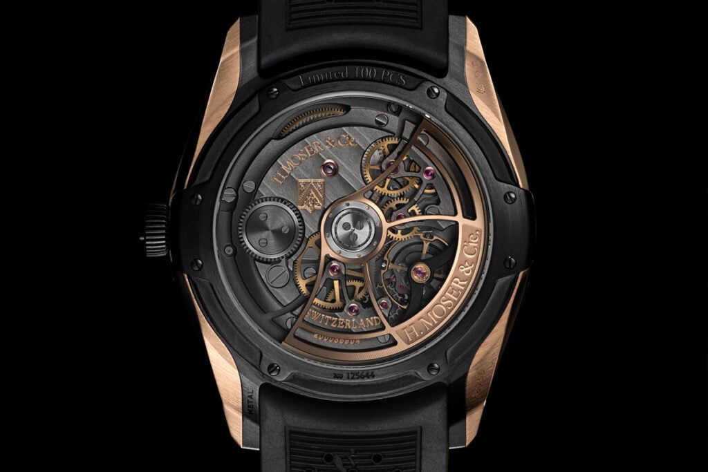 Fundo transparente de um relógio H. Moser & Cie., mostrando o movimento automático com rotor em ouro rosa e engrenagens visíveis.