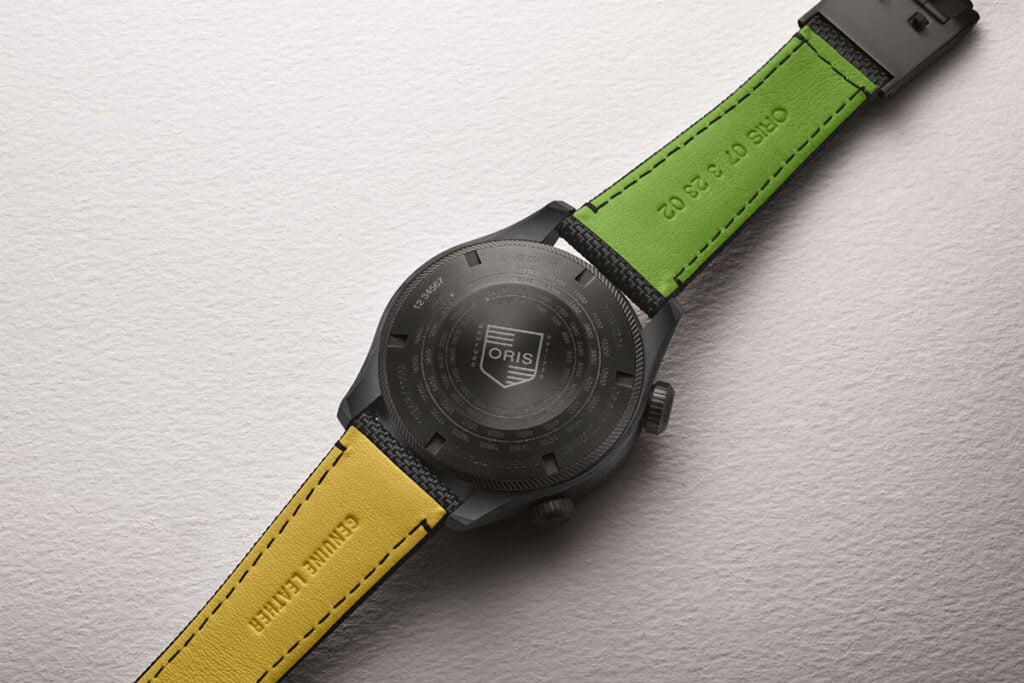 O fundo do relógio do Oris X BWD Limited Edition, com destaque para o forro da correia em duas cores, verde e amarelo.  Oris x Bamford Watch Department Mission Control Limited Edition