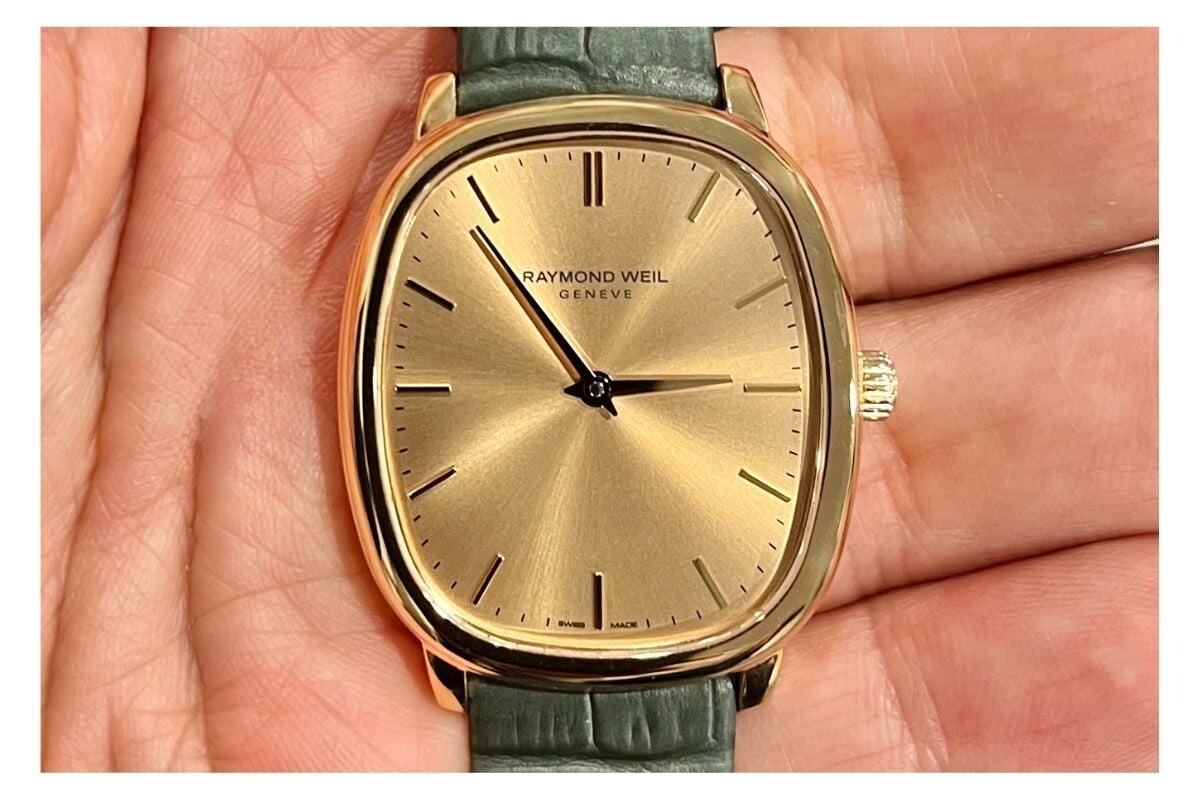 relógio Toccata Heritage da Raymond Weil na mão, dourado