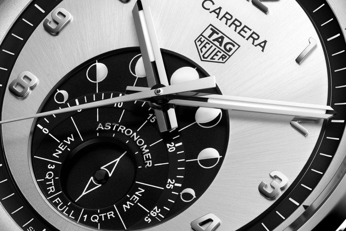 Close-up do mostrador do relógio TAG Heuer Carrera Astronomer com indicador de fases da lua e ponteiros em ouro rosa.