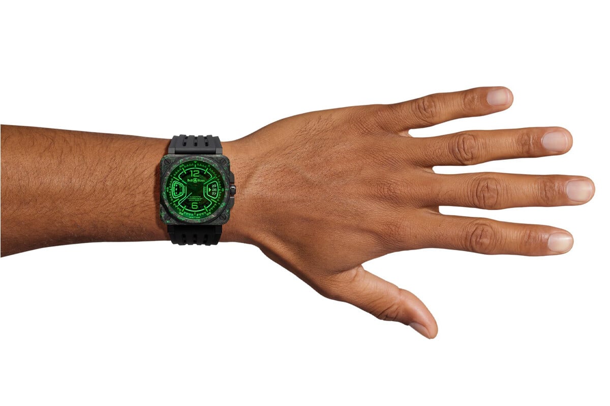 Relógio Bell & Ross BR-X3 Night Vision com mostrador preto e detalhes luminosos em verde, caixa quadrada de carbono e bracelete em borracha preta.