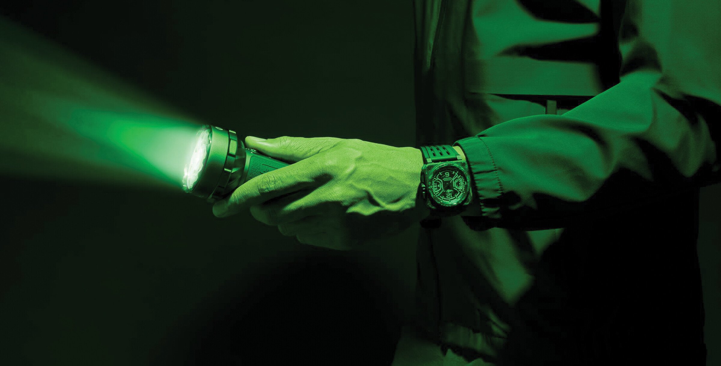 Relógio Bell & Ross BR-X3 Night Vision com mostrador preto e detalhes luminosos em verde, caixa quadrada de carbono e bracelete em borracha preta.