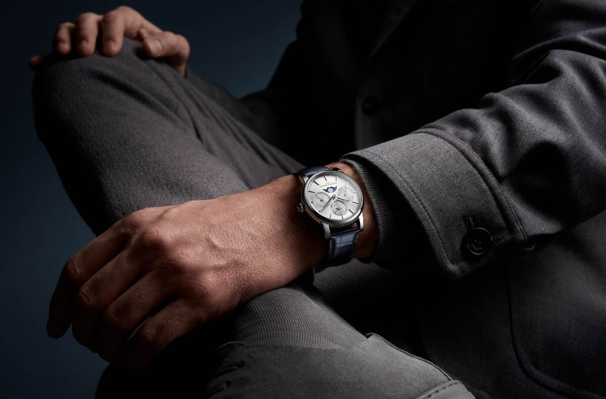 Frederique Constant Classic Perpetual Calendar Manufacture de mostrador prateado: num pulso masculino, com braço pousado numa perna que está cruzada