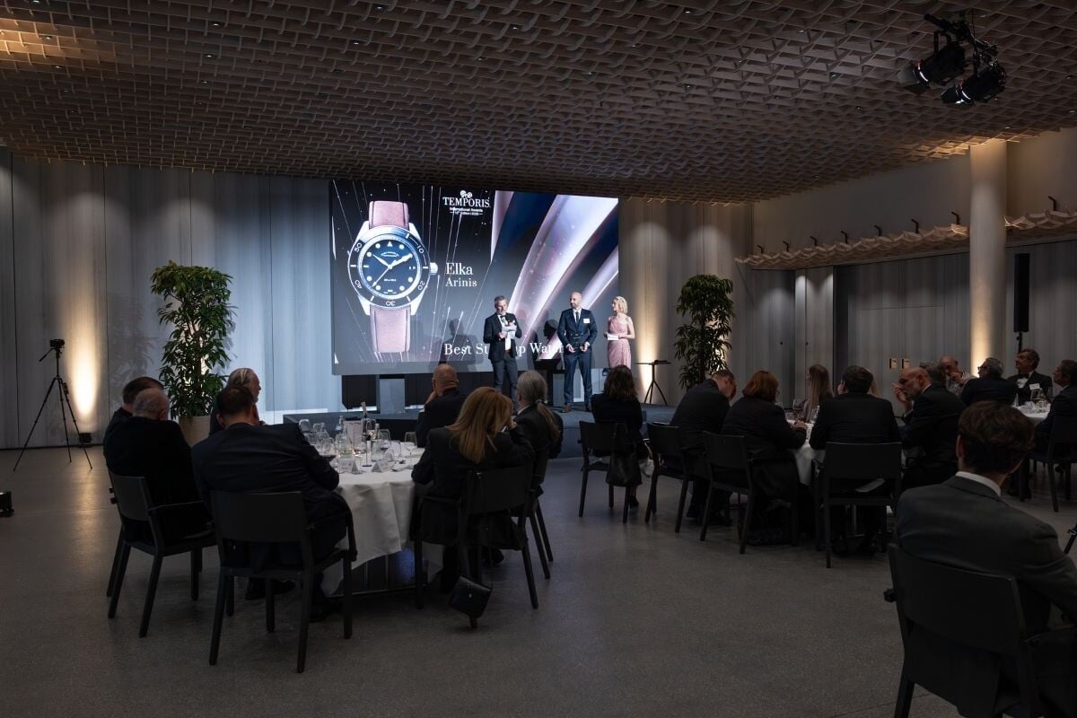 palco com apresentadores dos Temporis International Awards no Kongresshaus em Zurique e o relógio Elka Arinis que ganhou o Best Start-Up Watch e muitas pessoas sentadas à mesa