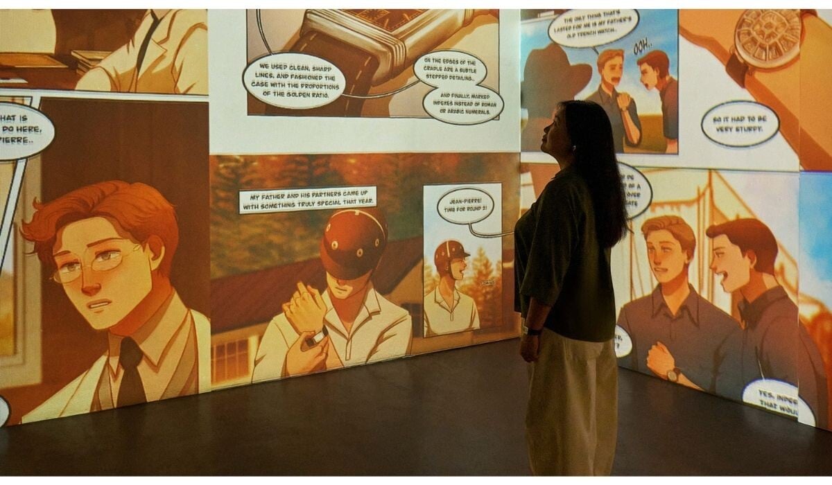 Olivecoat a olhar para uma parede onde se vê a webcomics Reverso por ela criada