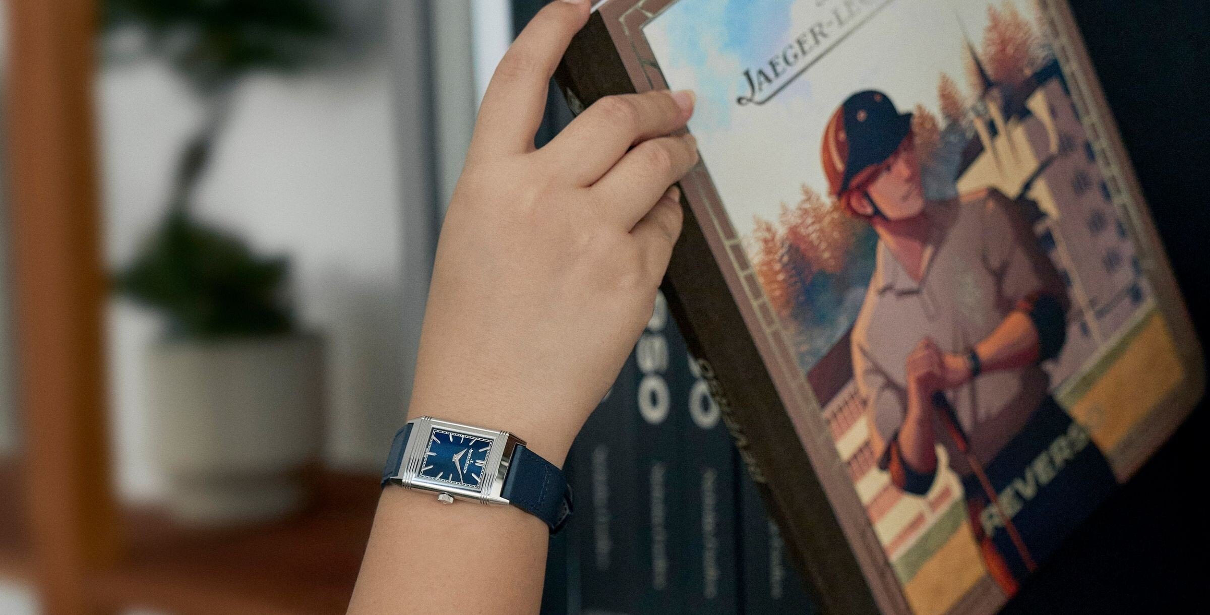 Uma mão segura o livro Reverso que nasce da webcomics de Olivecoat