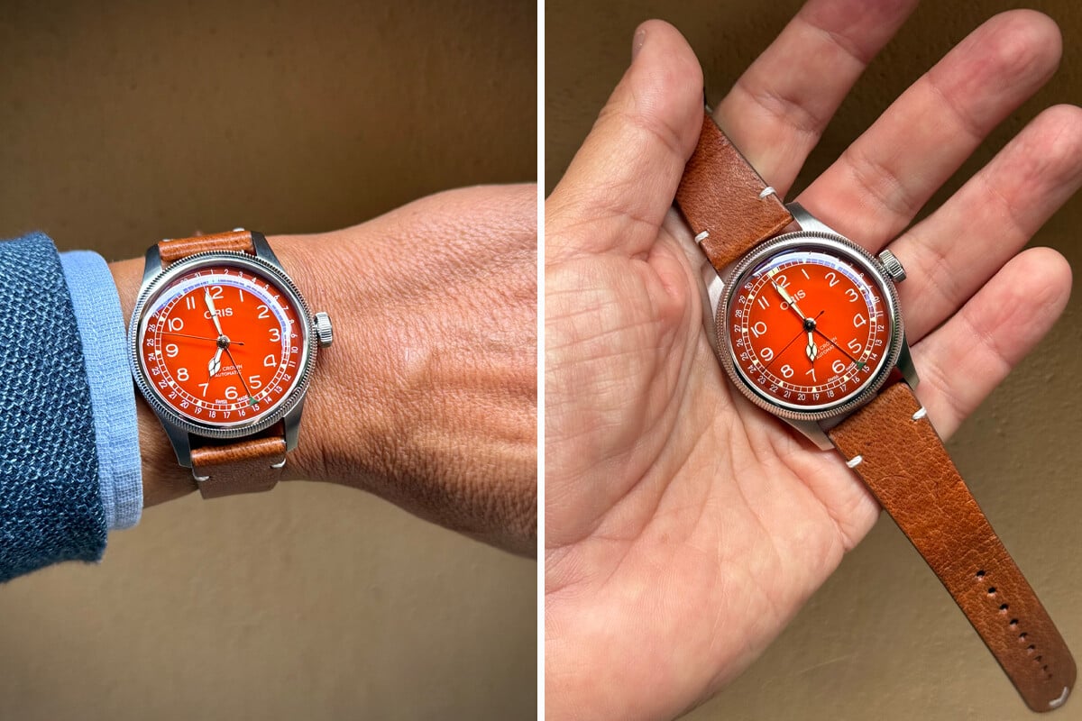 relógio em aço de mostrador avermelhado no pulso e na mão: o Oris Big Crown Pointer Date x Cervo Volante com correia de pele de veado