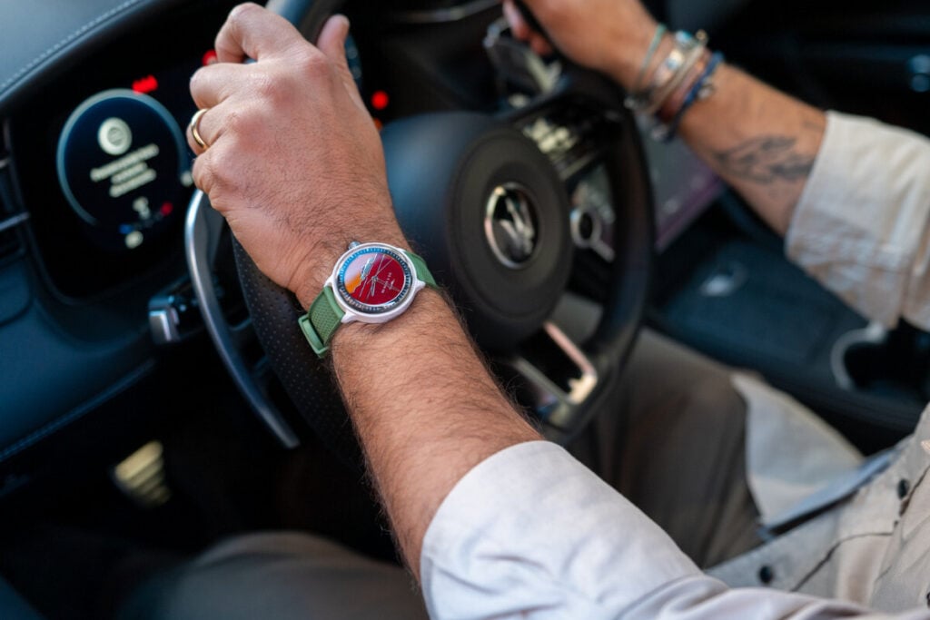um relógio De Rijke de mostrador vermelho no pulso ao volante de um Maserati | Foto: After Time by Milano Watch Week