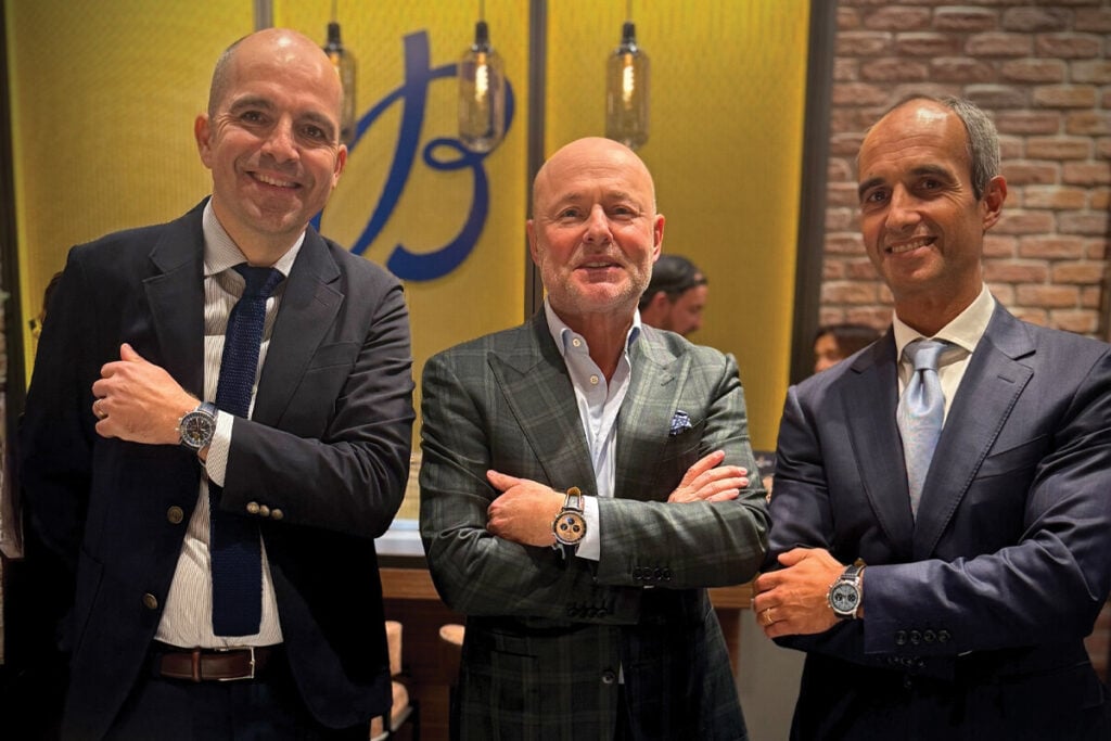 três homens de braços cruzados na boutique Breitling de Lisboa com relógios Breitling no pulso, incluindo Georges Kern e Pedro Rosas