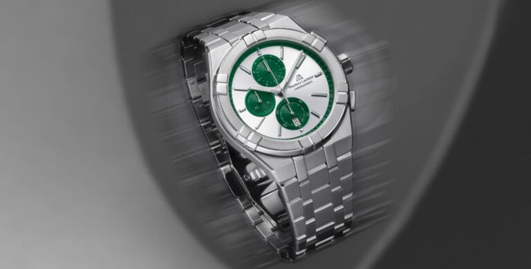 Relógio Maurice Lacroix prateado com mostrador verde e três subdials, em close-up sobre fundo desfocado.