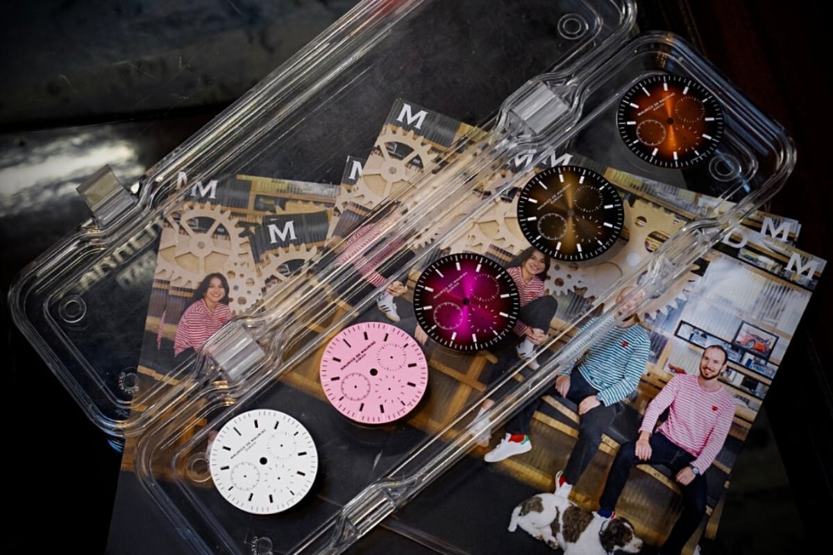 mostradores de relógio de diversas cores numa caixa de plástico em cima de uma mesa, marca Maurice de Mauriac, modelo L3 Chronograph