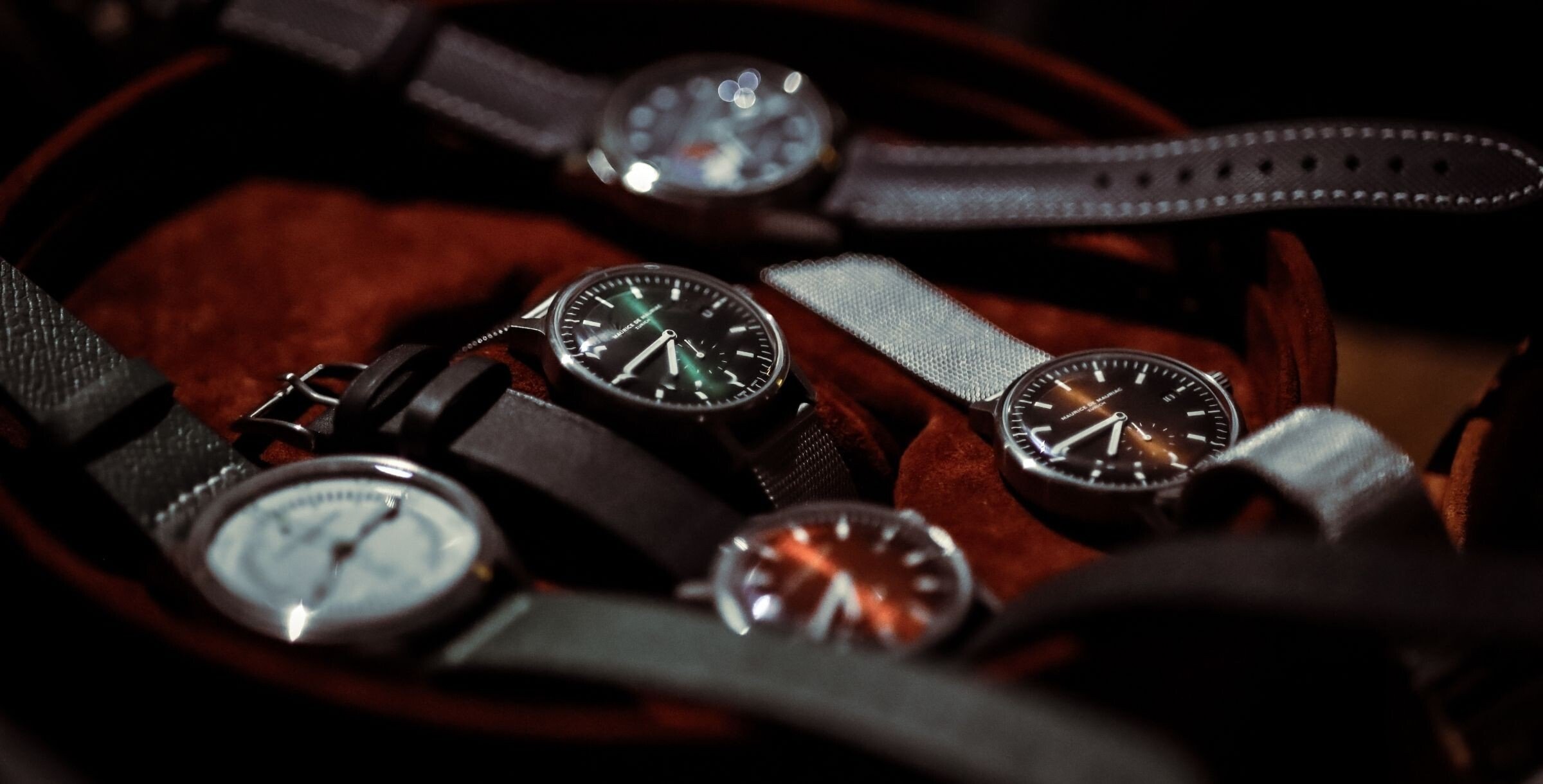 relógios numa caixa da marca Maurice de Mauriac e com mostradores de várias cores; fotografia de José Zenha