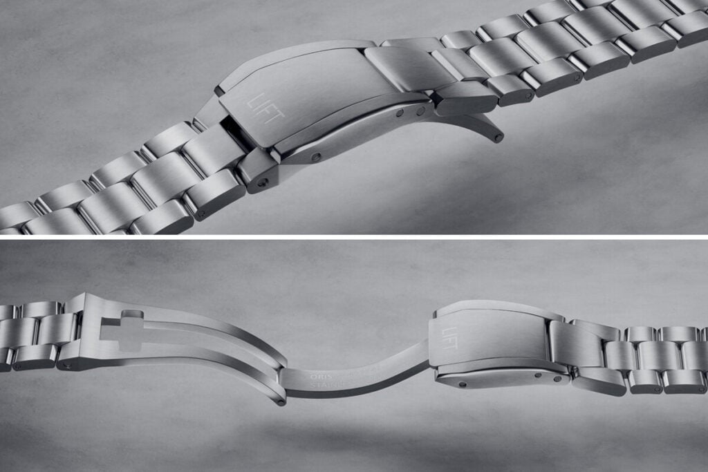 Imagem detalhada de uma pulseira de aço inoxidável de relógio, com foco no fecho com a inscrição "LIFT" e na parte de trás da fivela, mostrando o logótipo e o material de fabricação.