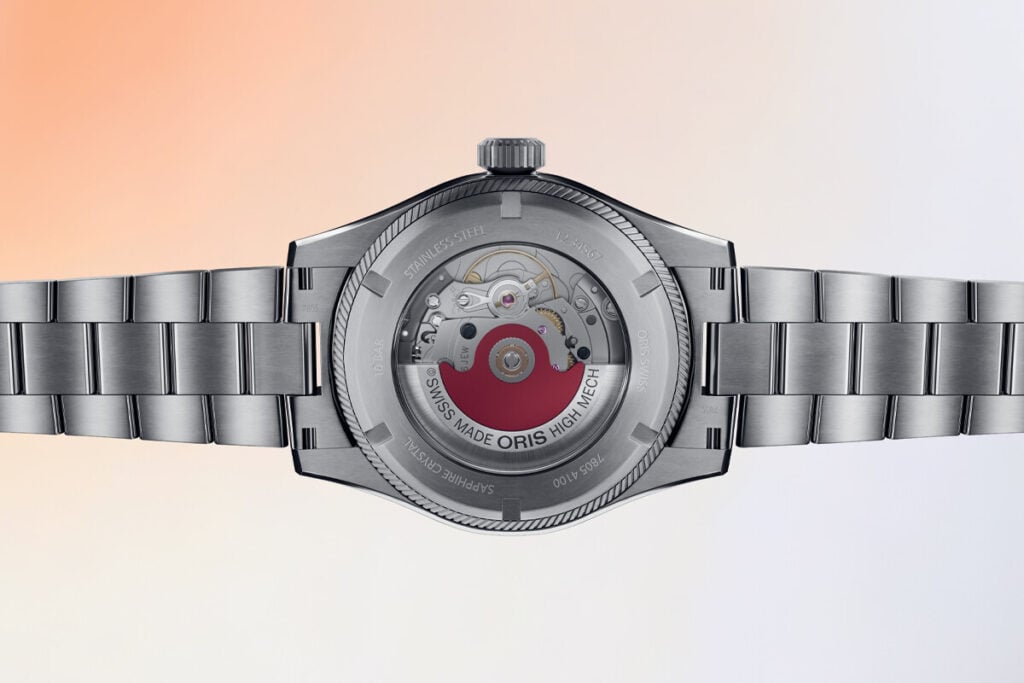 Imagem do verso de um relógio, destacando a caixa de aço inoxidável, a movimentação do mecanismo visível através do vidro transparente e as inscrições detalhadas, como "SWISS MADE" e "ORIS."