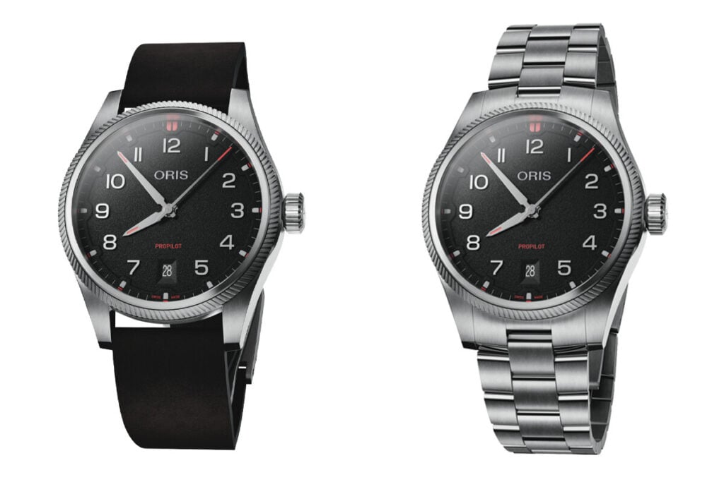 Dois modelos do relógio Oris ProPilot com mostrador preto, um com pulseira de borracha preta e o outro com bracelete metálico prateado. Ambos têm numerais grandes e detalhes vermelhos nos ponteiros e no logo, além de uma janela de data na posição das 6 horas.