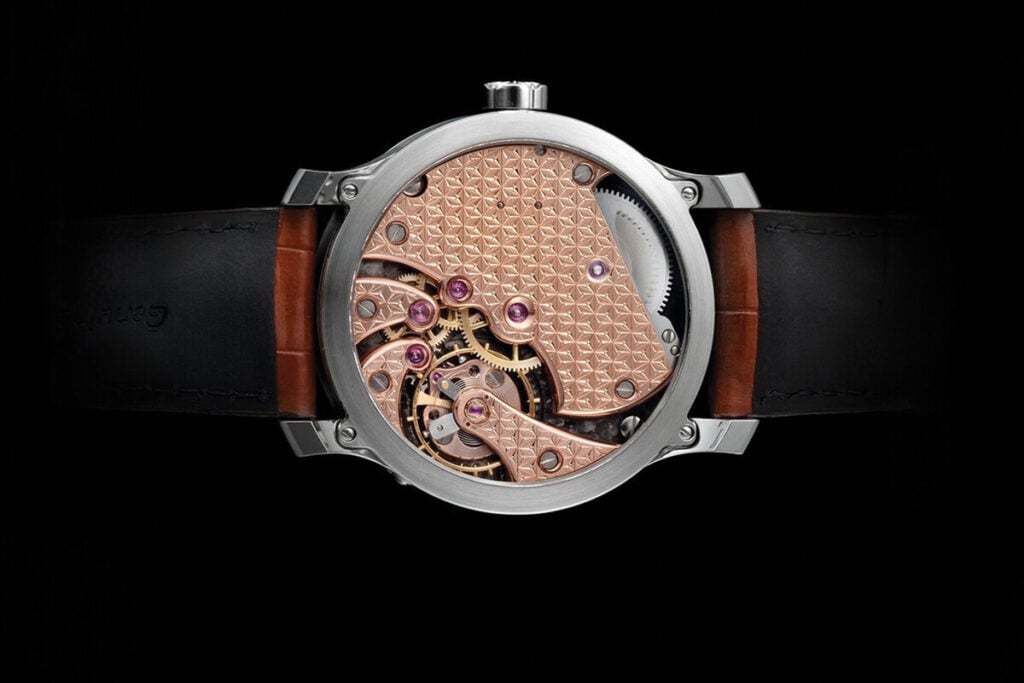 "Fundo de um relógio de luxo mostrando um mecanismo complexo com engrenagens, pedras preciosas (rubis) e detalhes de cobre. O design é elegante e a pulseira é de couro escuro."