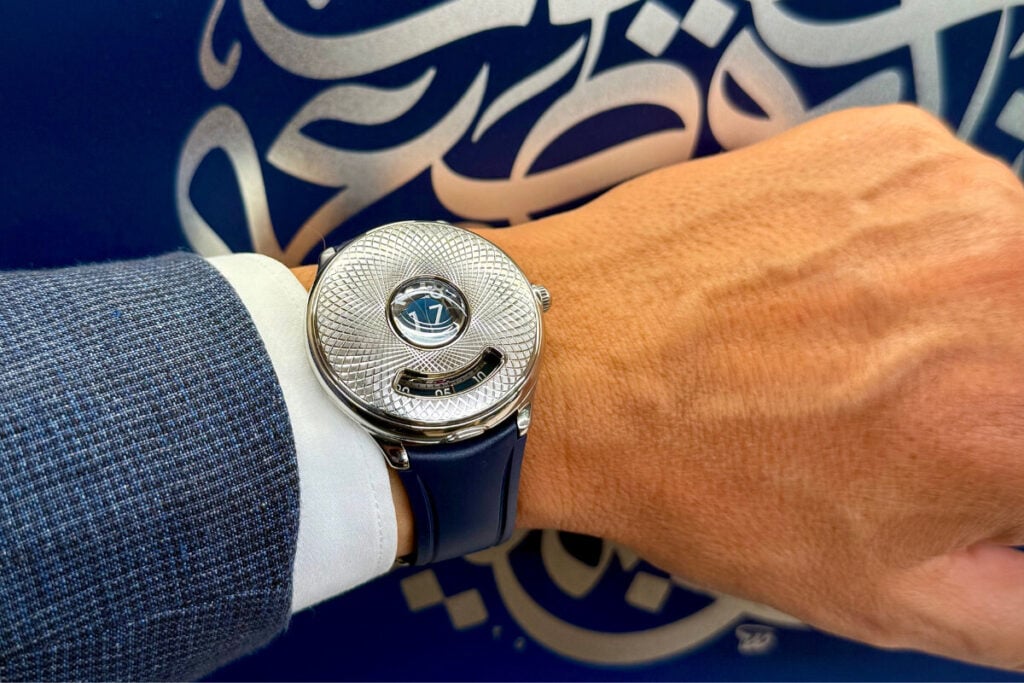 relógio no pulso com tampa fechada e discos das horas Czapek Time Jumper com arabescos por trás