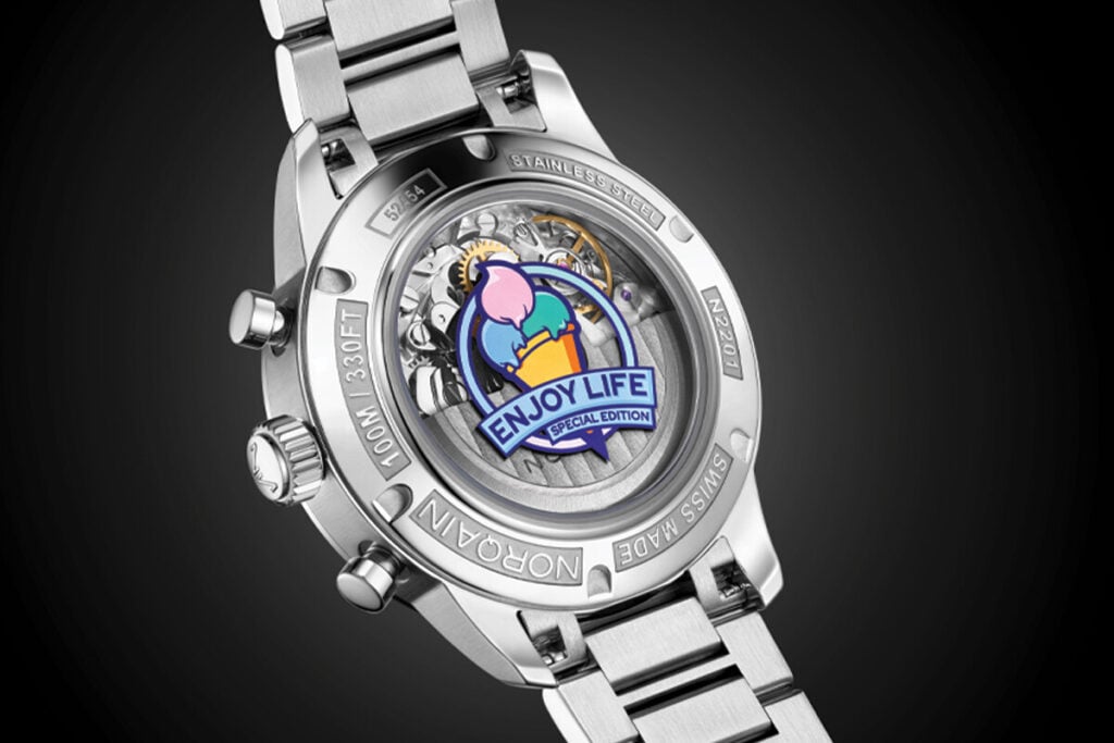 Vista traseira de um rel&oacute;gio NORQAIN em a&ccedil;o inoxid&aacute;vel, com fundo transparente e emblema &lsquo;Enjoy Life &ndash; Special Edition&rsquo;.
