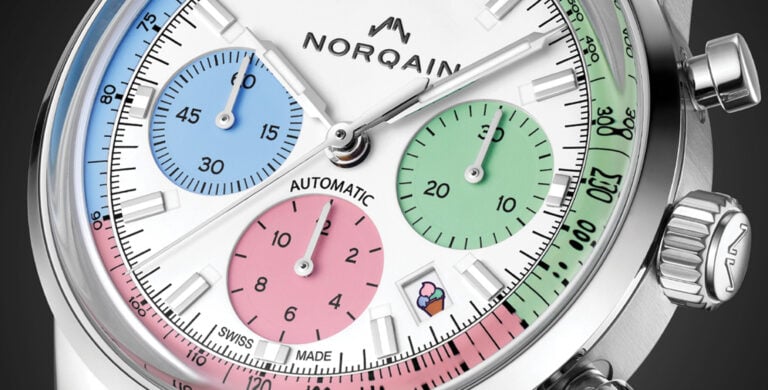 Pormenor do mostrador de um relógio cronógrafo com submostradores coloridos e escala taquimétrica.