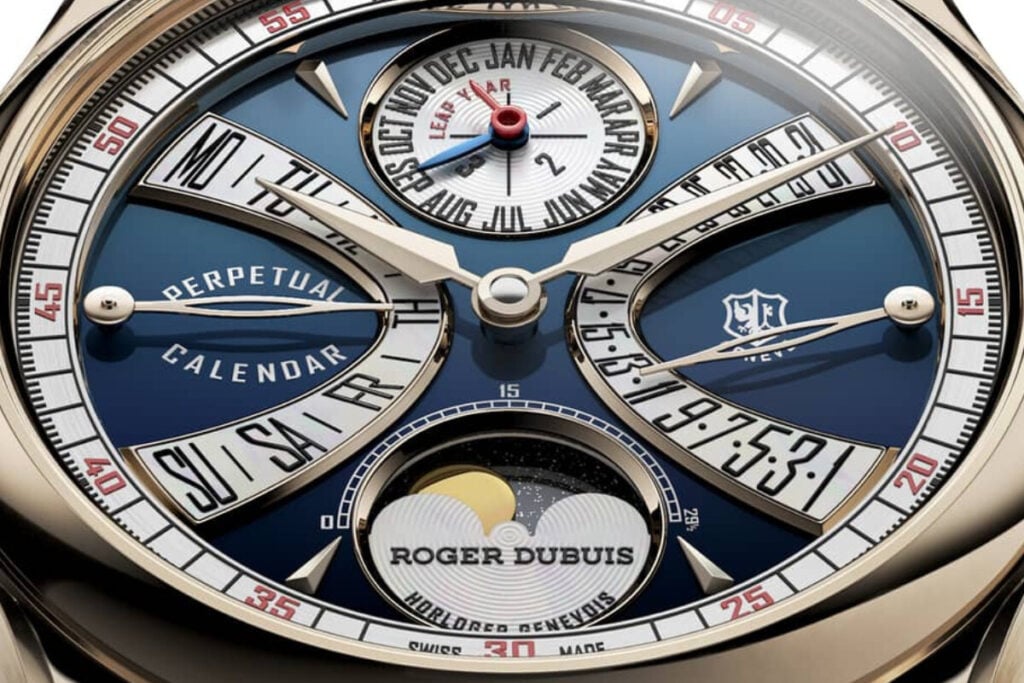 pormenor do mostrador do rel&oacute;gio de luxo Hommage La Placide da marca Roger Dubuis com mostrador azul, ponteiros em ouro retr&oacute;grados, calend&aacute;rio perp&eacute;tuo com fases da lua em aventurine e segmentos em madrep&eacute;rola