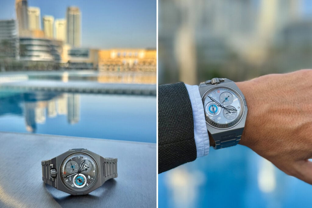 Rel&oacute;gio de luxo Urwerk em tit&acirc;nio, com mostrador t&eacute;cnico, fotografado sobre uma superf&iacute;cie junto a uma piscina e no pulso de uma pessoa, com edif&iacute;cios ao fundo.