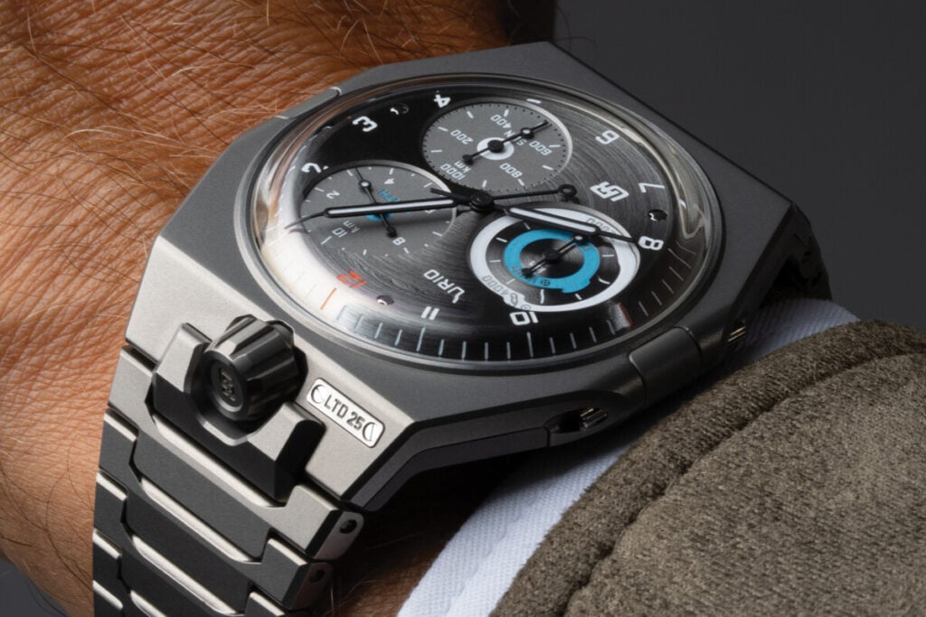 Rel&oacute;gio de pulso da marca Urwerk, modelo com design futurista e mostrador complexo. O rel&oacute;gio exibe v&aacute;rios submostradores com marcadores em azul e prateado, al&eacute;m de um case de titanio e uma bracelete de metal.