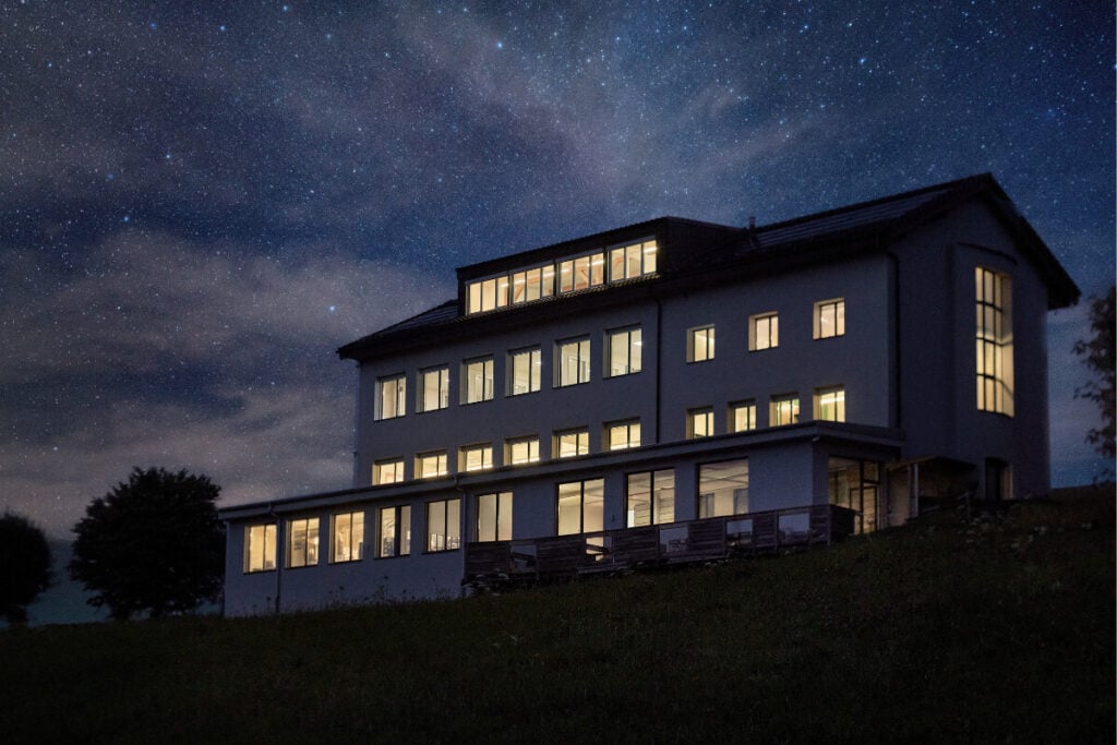 vista à noite do edifício da Manufatura De Bethune em L'Auberson Sainte-Croix na Suíça Project LVDB-03 Louis Varius: Louis Vuitton + De Bethune
