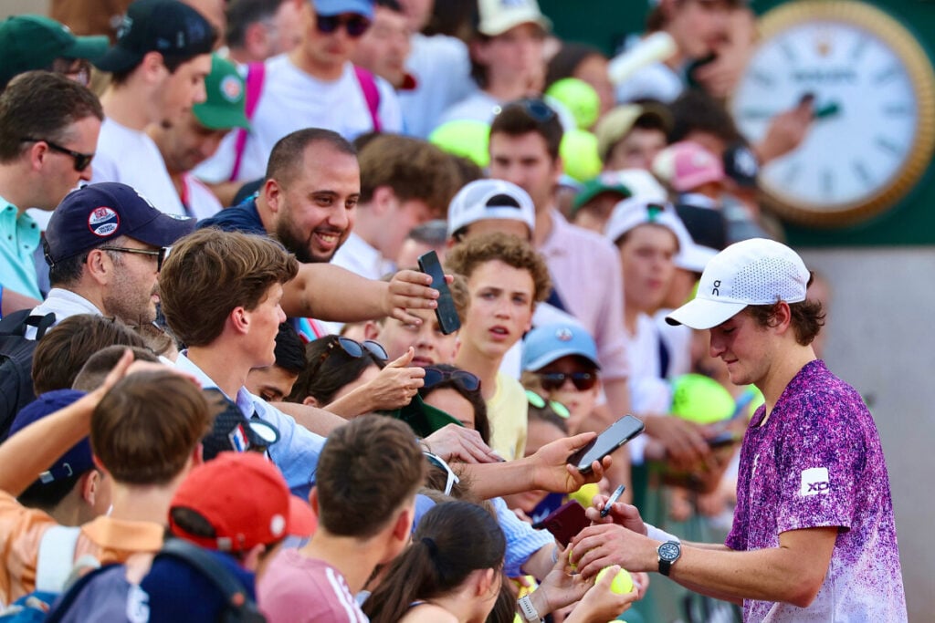 jogador de ténis a dar autógrafos a muita gente com relógio por trás Roland Garros 2026 Rolex 6 João Fonseca | Foto: Rolex