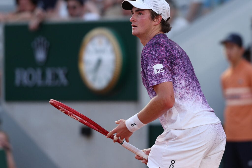 jogador de ténis com raqueta e relógio por trás Roland Garros 2026 Rolex 6 João Fonseca | Foto: Rolex