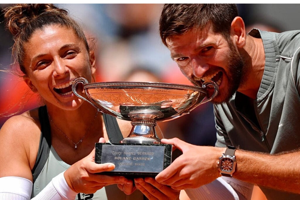jogadora e jogador de ténis com relógio no pulso a levantar taça de Roland Garros 2026: Sara Errani e Andrea Vavassori com Gerald Charles | Foto: Roland Garros
