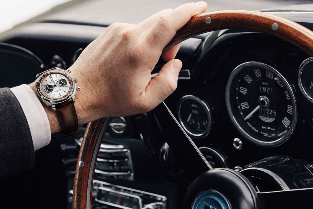 mão ao volante com Breitling Top Time B01 Chronograph 41 Tribute to Aston Martin DB5 1 | Foto: Breitling