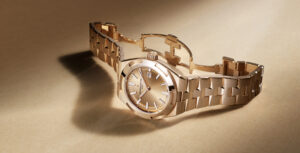 Relógio Vacheron Constantin Overseas Self-Winding 34,5 mm em ouro rosa 18 quilates, com mostrador dourado, pulseira integrada em ouro rosa e fecho desdobrável aberto.